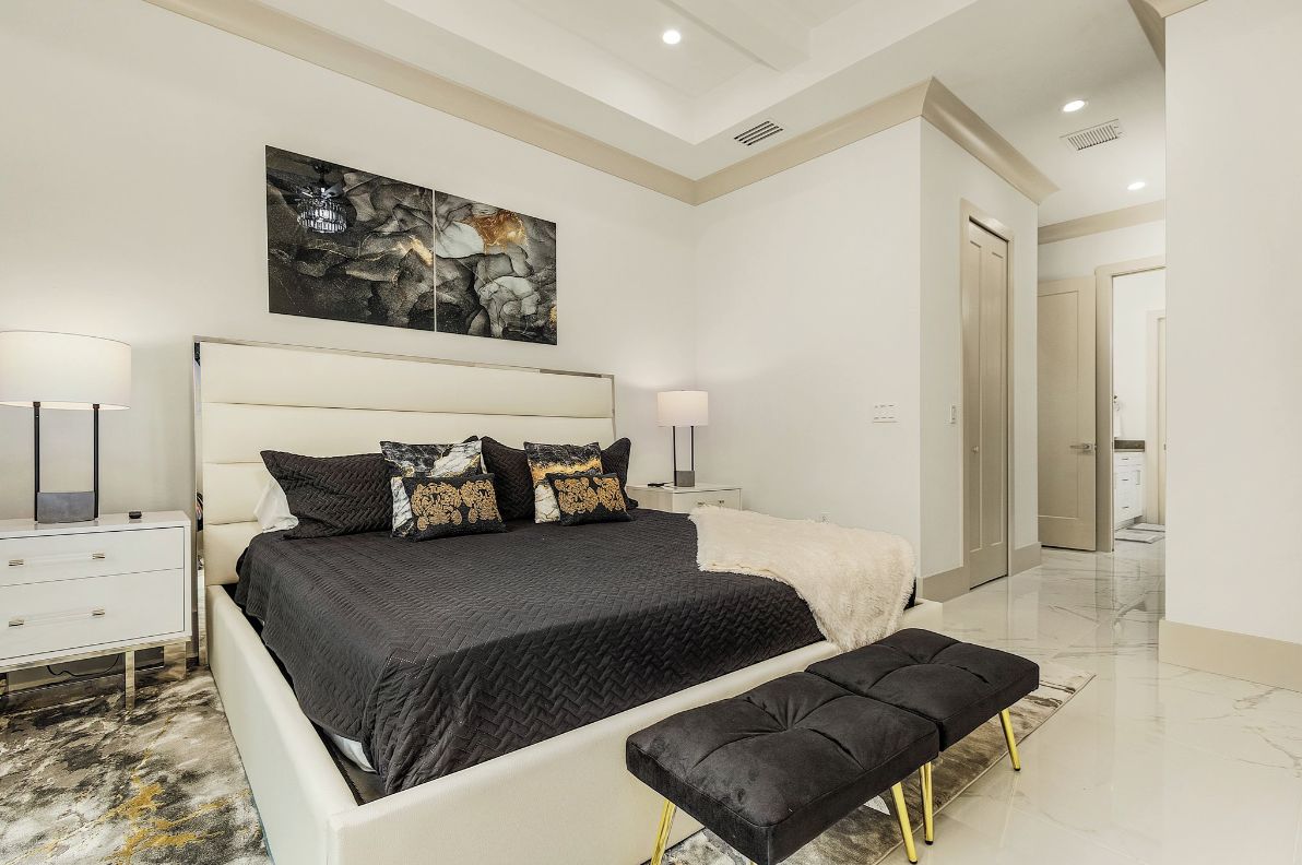 A modern bedroom with a large bed, bedside tables, and a bench.