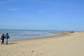 A beach with a wide sandy shore and a calm sea. - Holiday apartment with 3 bedrooms (Oudkarspel)