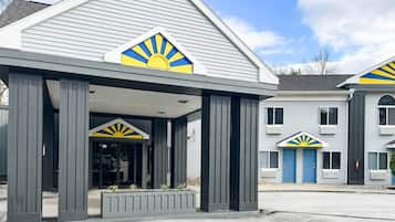 A building with a covered entrance and a distinctive sun design on the roof.