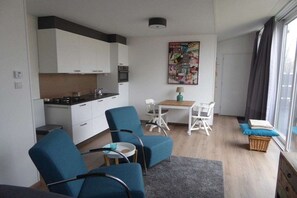 Ein gemütlicher Wohnbereich mit Küchenzeile, Essplatz und Sitzgelegenheiten.