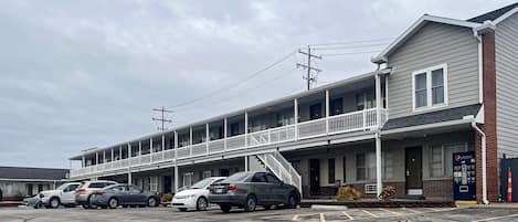 A motel with a two-story structure, a covered parking area, and a visible Pepsi vending machine.
