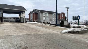 A parking lot with a gas station and a multi-story building in the background.