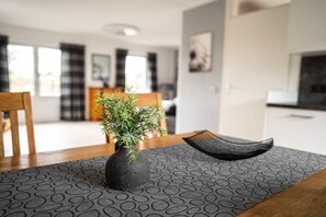 A dining area with a table, chairs, a vase with a plant, and a patterned rug. - North Sea Park Ouddorp - Müntefehr (Ouddorp)