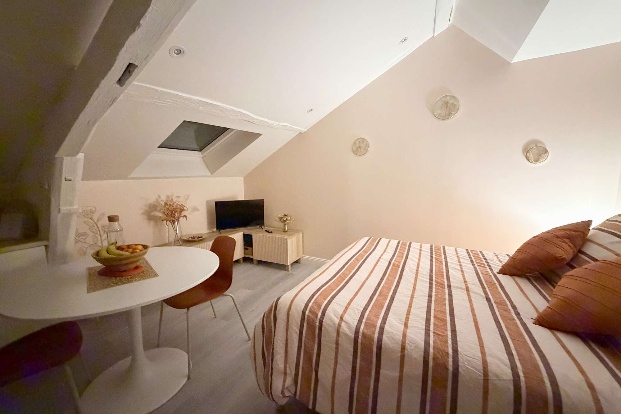 Habitació compacte amb llit, escriptori i televisió.