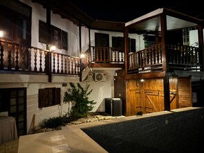 Un bâtiment à deux étages doté d’un balcon, d’une piscine et d’un portail.