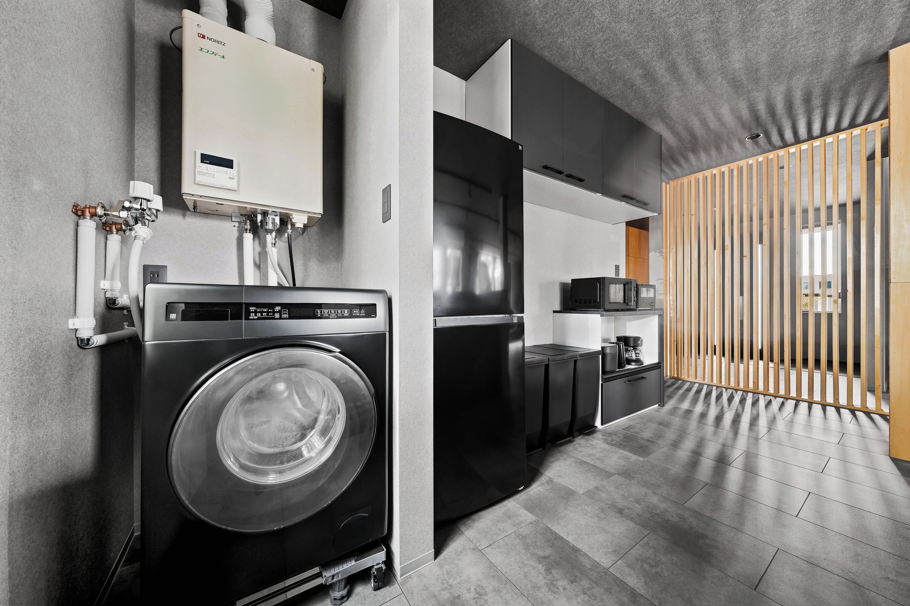 A modern kitchen with a built-in washer and dryer, a microwave, and a coffee maker.