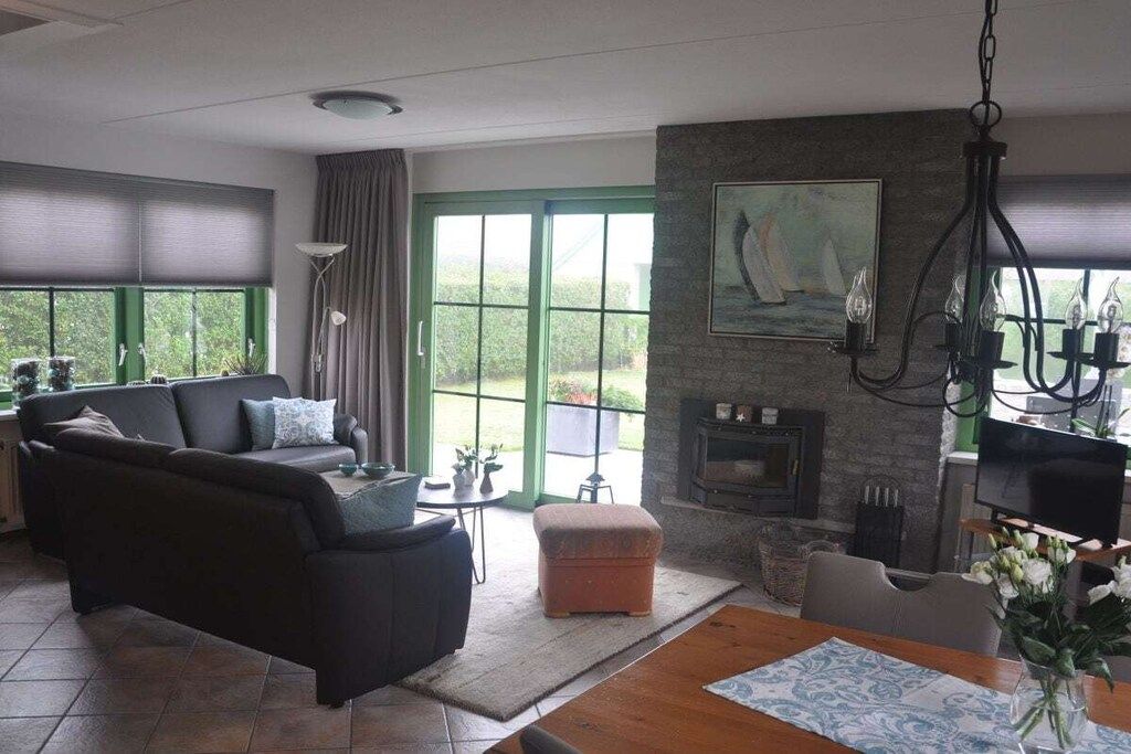 A living room with a fireplace, a sofa, a dining table, and a television.