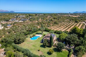 An aerial view of a residential area with a swimming pool, a tennis court, and a large house with solar panels. - House with pool Son San Marti Gran Muro (Muro)