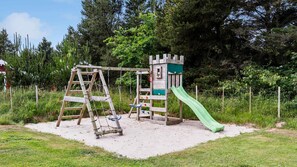 Un parque infantil con tobogán y estructuras para escalar.