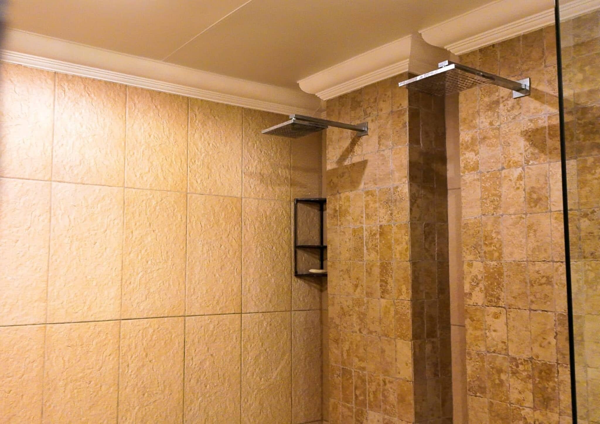 A shower area with tiled walls and a glass partition.
