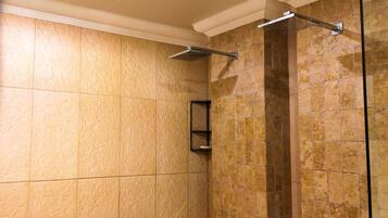 A shower area with tiled walls and a glass partition.