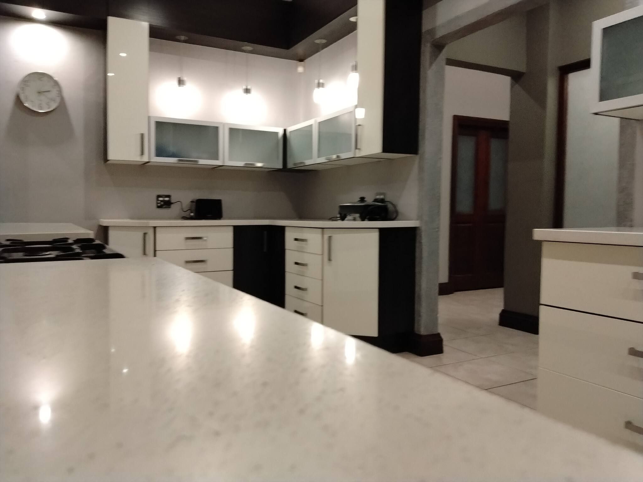 A modern kitchen with white cabinets, a central island, and built-in appliances.
