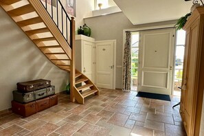 Eine Treppe führt zu einer Zwischenebene mit weißen Türen und einem kleinen Schrank.
