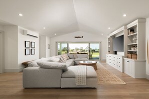 Een moderne woonkamer met een hoekbank, een salontafel en een tv-meubel met opbergruimte.