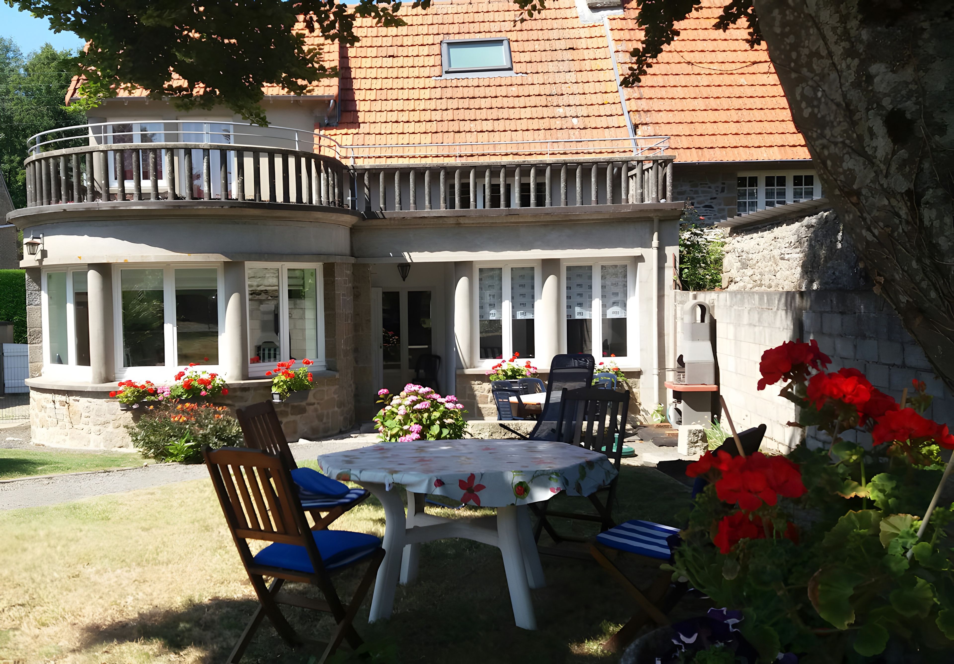 A courtyard with a round table, chairs, and potted plants.