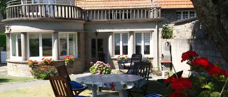 A courtyard with a round table, chairs, and potted plants.