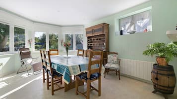 Une salle à manger avec une table dressée pour quatre personnes, entourée de chaises en bois.