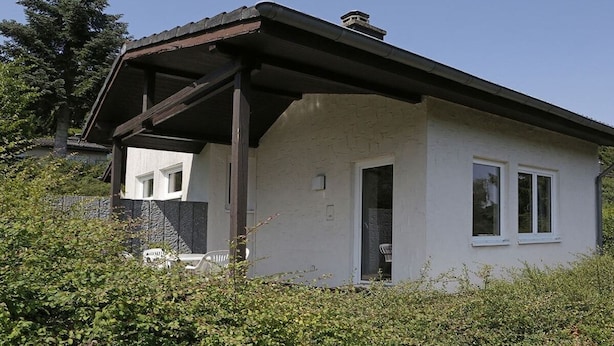 A single-story house with a covered porch, a visible door, and a window.
