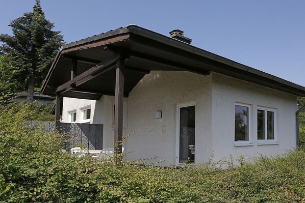A single-story house with a covered porch, a visible door, and a window.