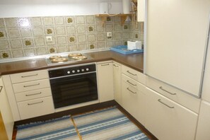 A kitchen with a stove, oven, and white cabinets. - Holiday apartment with 1 bedroom (Sonthofen)