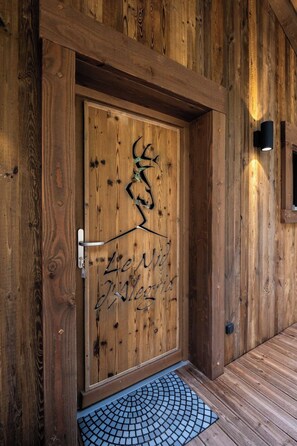 A wooden door with a metal sculpture and the inscription 'Le Nid de Verrecia.' - ✨ Le Nid d'Alegria – Luxury Mountain Retreat at the Foot of the Slopes (La Bresse)