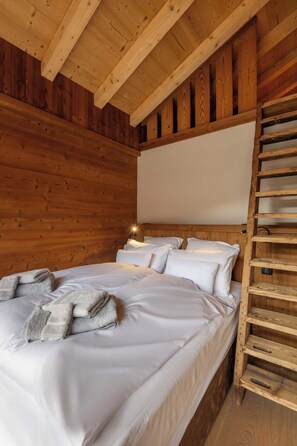 A wooden cabin bedroom with a bed, pillows, a ladder, and a white wall. - ✨ Le Nid d'Alegria – Luxury Mountain Retreat at the Foot of the Slopes (La Bresse)