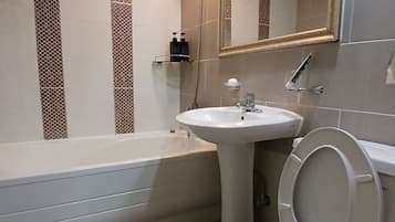 Une salle de bain avec une baignoire, un lavabo et des toilettes.