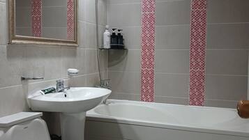 A bathroom with a toilet, sink, and bathtub.