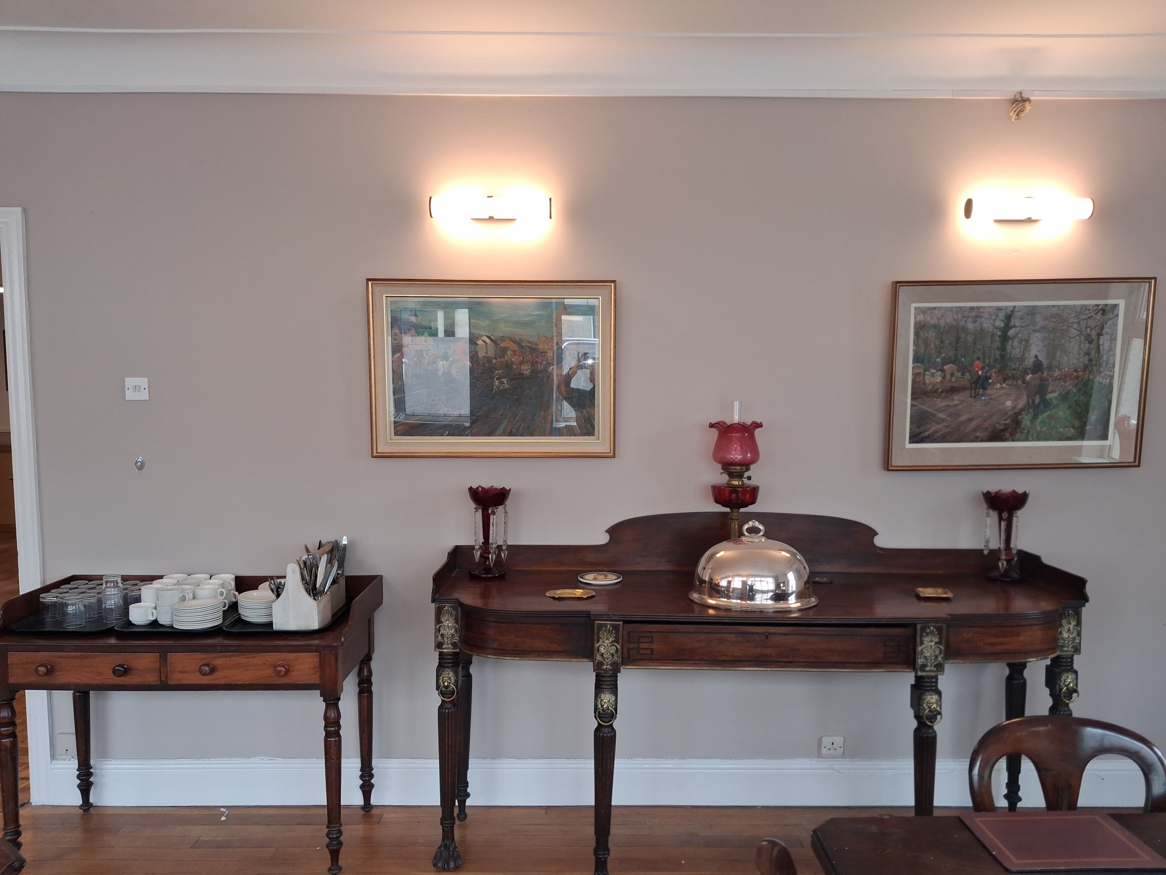 Un comedor con dos mesas de madera, cada una con un cuadro enmarcado encima.
