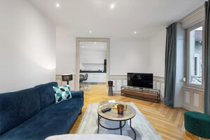 A modern living room with a sofa, coffee table, and a TV. - L'Appart June - 4 Guests - In the Heart of Town (Gérardmer)