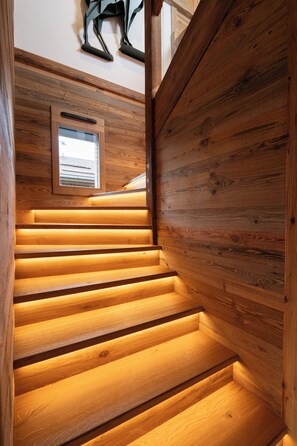 Un escalier en bois avec une fenêtre intégrée en haut.