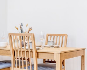 A wooden dining table with two chairs, a vase with dried plants, and empty wine glasses. - Douceur du Lac - Gérardmer, Vosges (Gérardmer)