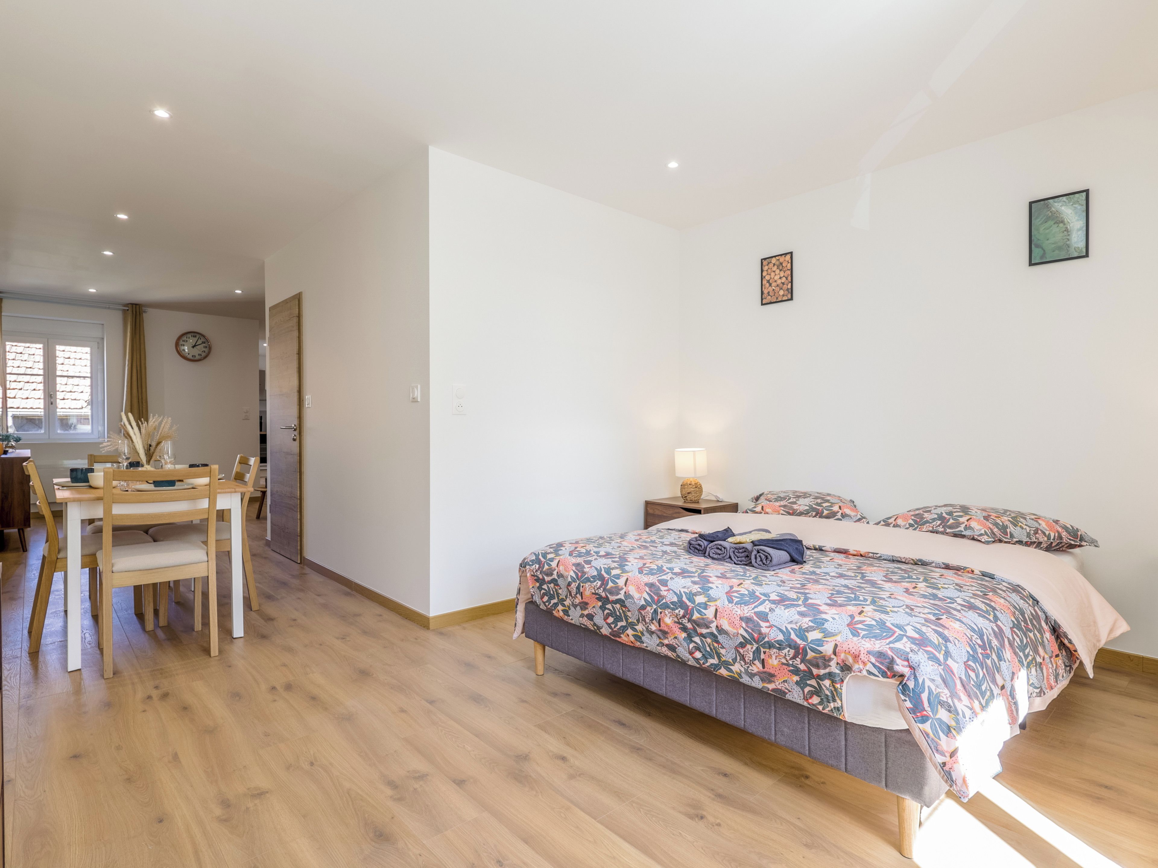 Une chambre à coucher avec un lit, une table de chevet et une fenêtre.