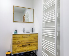 A bathroom with a white sink, wooden vanity, and a mirror with a gold frame. - Souffle du Lac - Gérardmer, Vosges (Gérardmer)