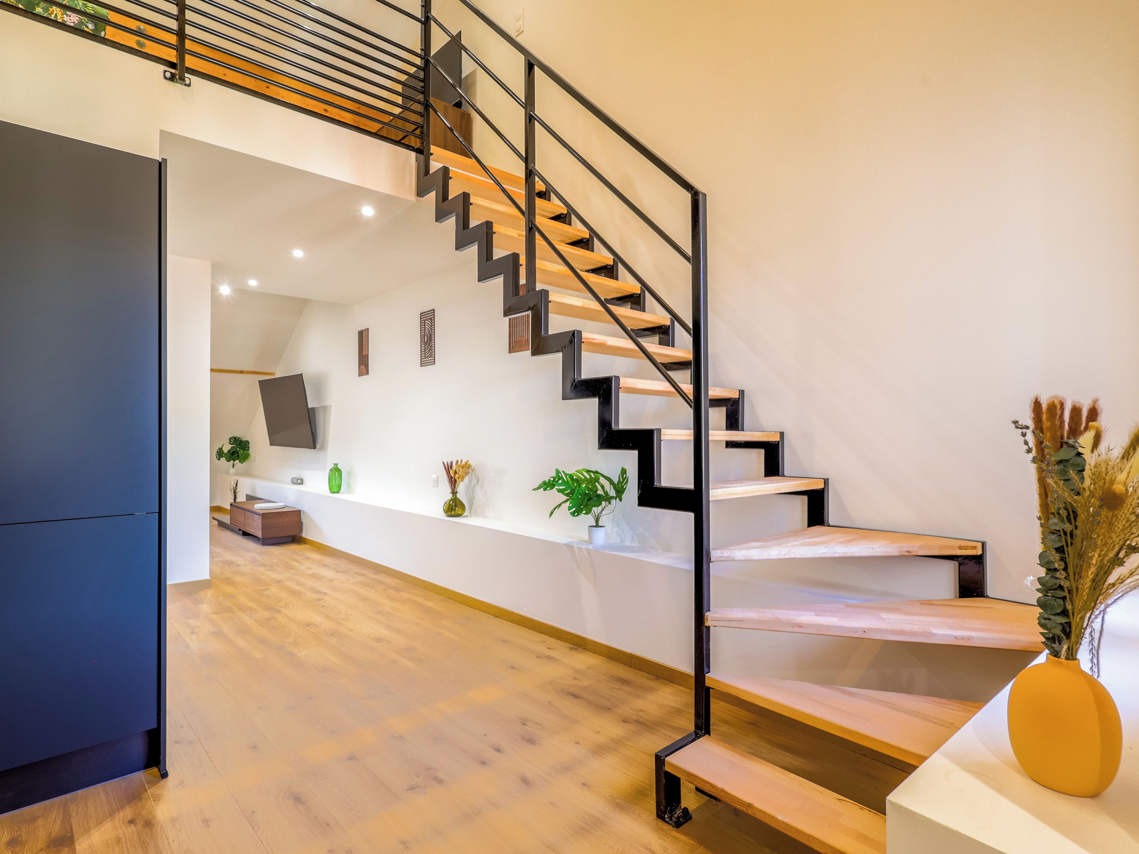 A modern interior with a staircase, wooden flooring, and a minimalist design.