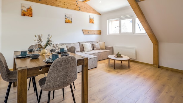 Ein Essbereich mit Holztisch und Stühlen, einer Couch und einem kleinen Couchtisch.