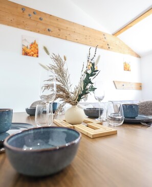 A dining table with a vase of dried plants, several glasses, and bowls. - Souffle du Lac - Gérardmer, Vosges (Gérardmer)