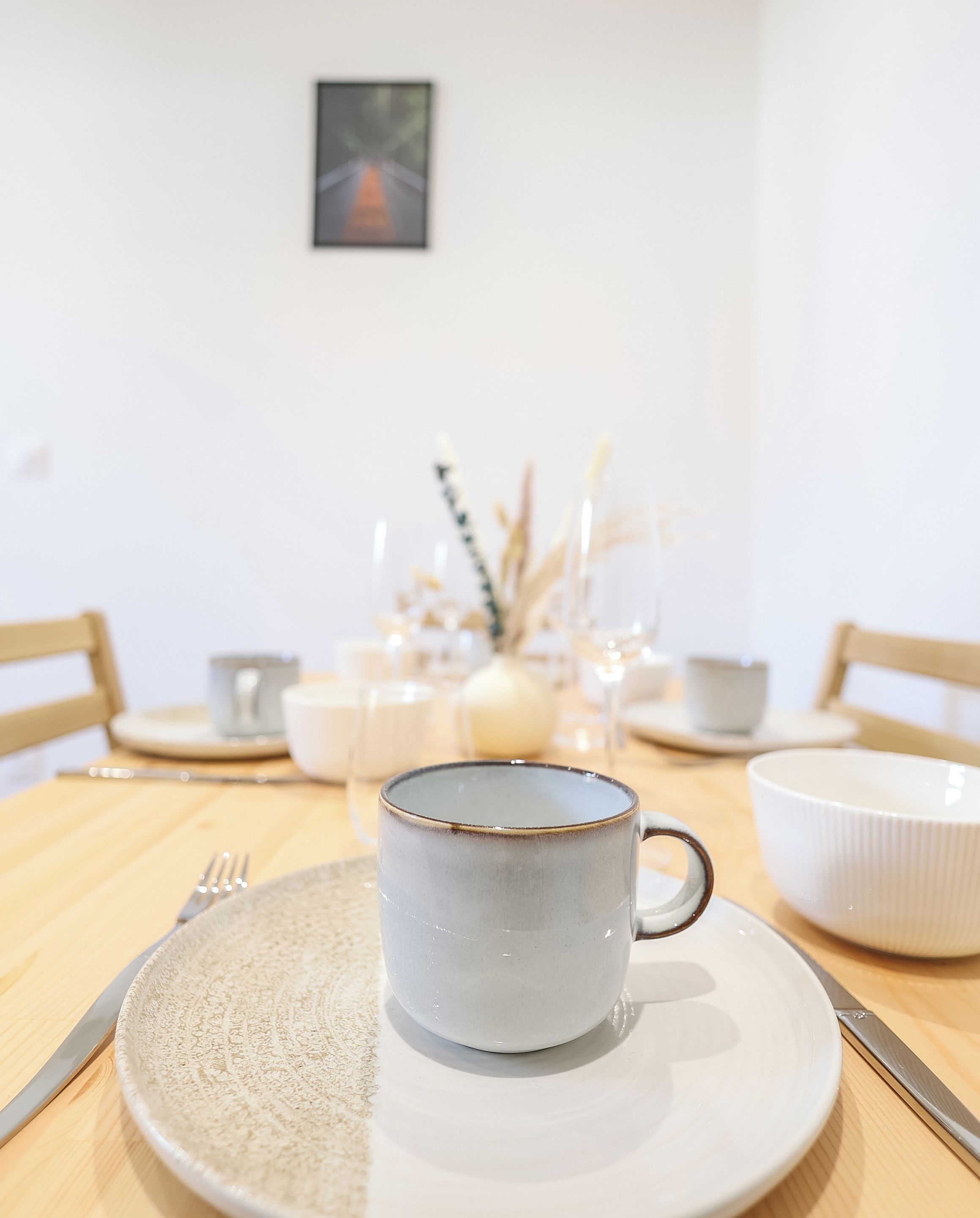 Una mesa con un plato, una taza y un bol.