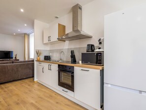A modern kitchen with a built-in microwave, oven, and a coffee maker on the countertop. - Écume du Lac - Gérardmer, Vosges (Gérardmer)