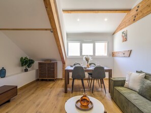 Un espace repas comprenant une table en bois, des chaises et un canapé.