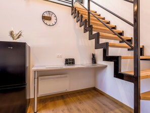 A kitchen with a built-in stove, a toaster, and a clock on the wall. - L'Éveil du Lac ★ Downtown • Walk to the Lake • Netflix • Wi-Fi • King Bed (Gérardmer)