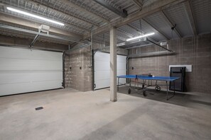 Un vaste espace intérieur aux murs en béton, doté d’une table escamotable et d’un éclairage au plafond.