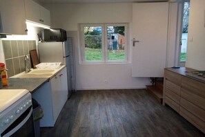 A kitchen with a built-in oven, a microwave, a sink, and a window with a view of the outside. - Holiday home with 1 bedroom (L'Isle-Jourdain)