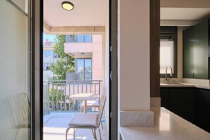 Ein Blick ins Innere einer modernen Wohnung mit Balkon, Essbereich und Küche.