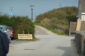 Ein Weg, der zu einem Hotel führt, mit einem Wegweiser.