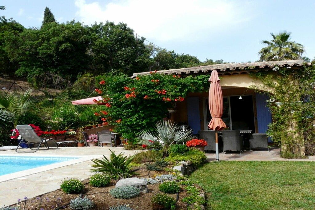 A residential property with a swimming pool, outdoor seating, and a garden.