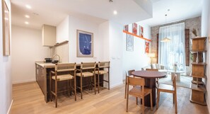 Una cocina moderna con comedor, muebles de madera y obras de arte en las paredes.