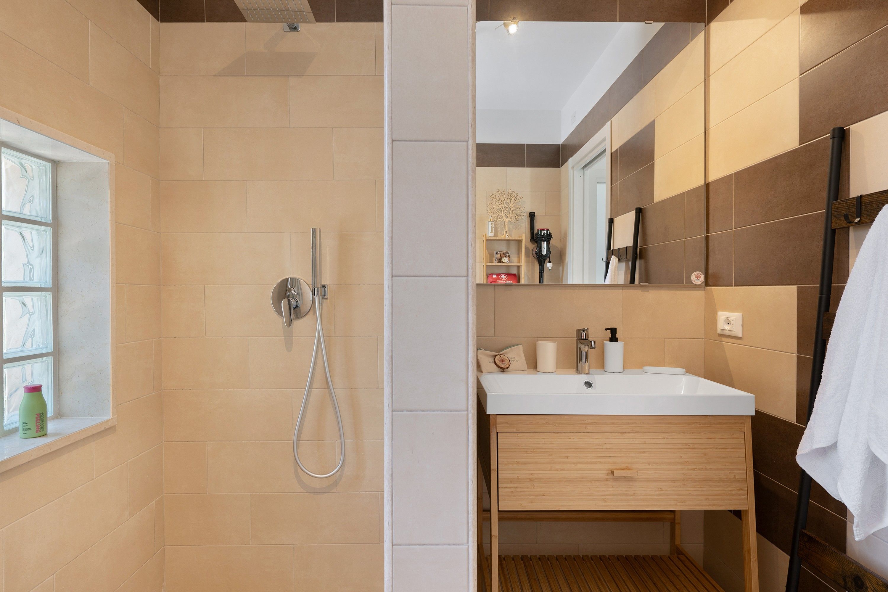 Un baño moderno con ducha, lavamanos y espejo.