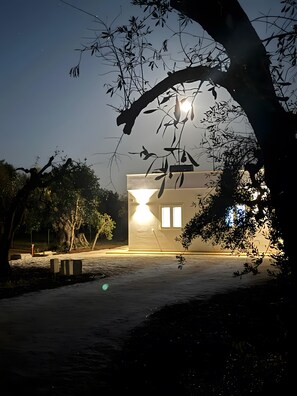 Un edificio con tetto piatto, una finestra visibile e un vialetto che vi conduce.