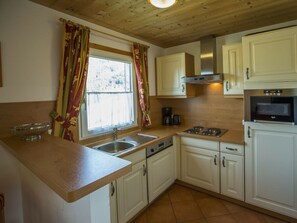 A kitchen with white cabinets, a stainless steel sink, a stove, and a built-in oven. - Cabin in Annaberg With Swimming Pool (Annaberg-Lungoetz)